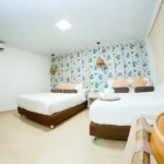 habitacion cuadruple cuenta con dos camas dobles un decorado tropical aire acondicionado para que estes en un ambiente relajado un televisor y una pequeña nevera